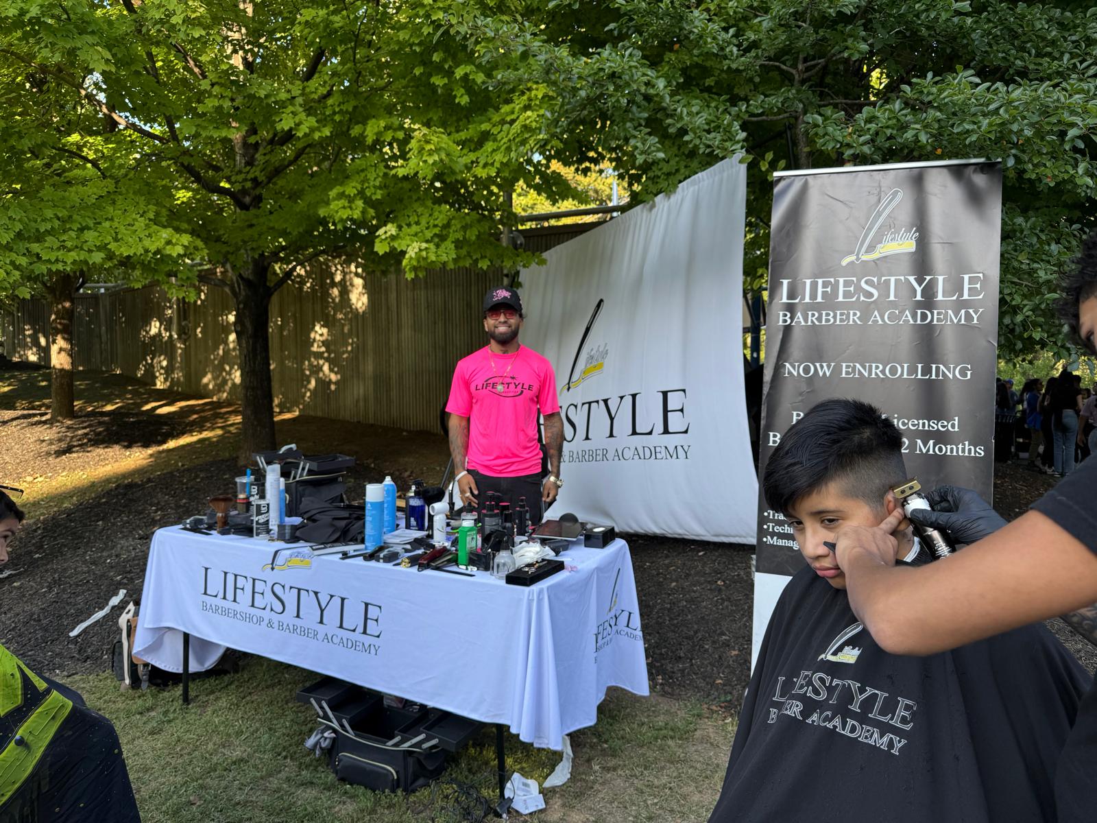 Community barber academy providing a haircut at its booth