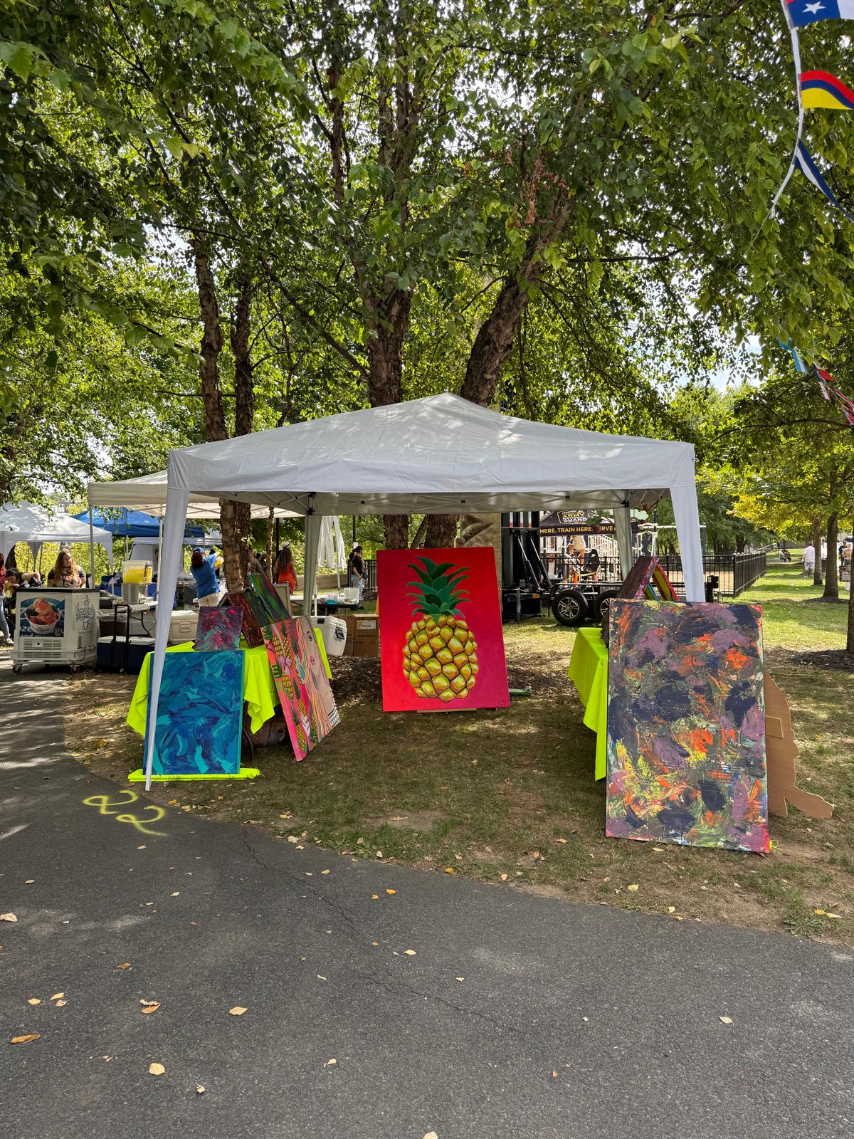 Outdoor art vendor booth with colorful paintings