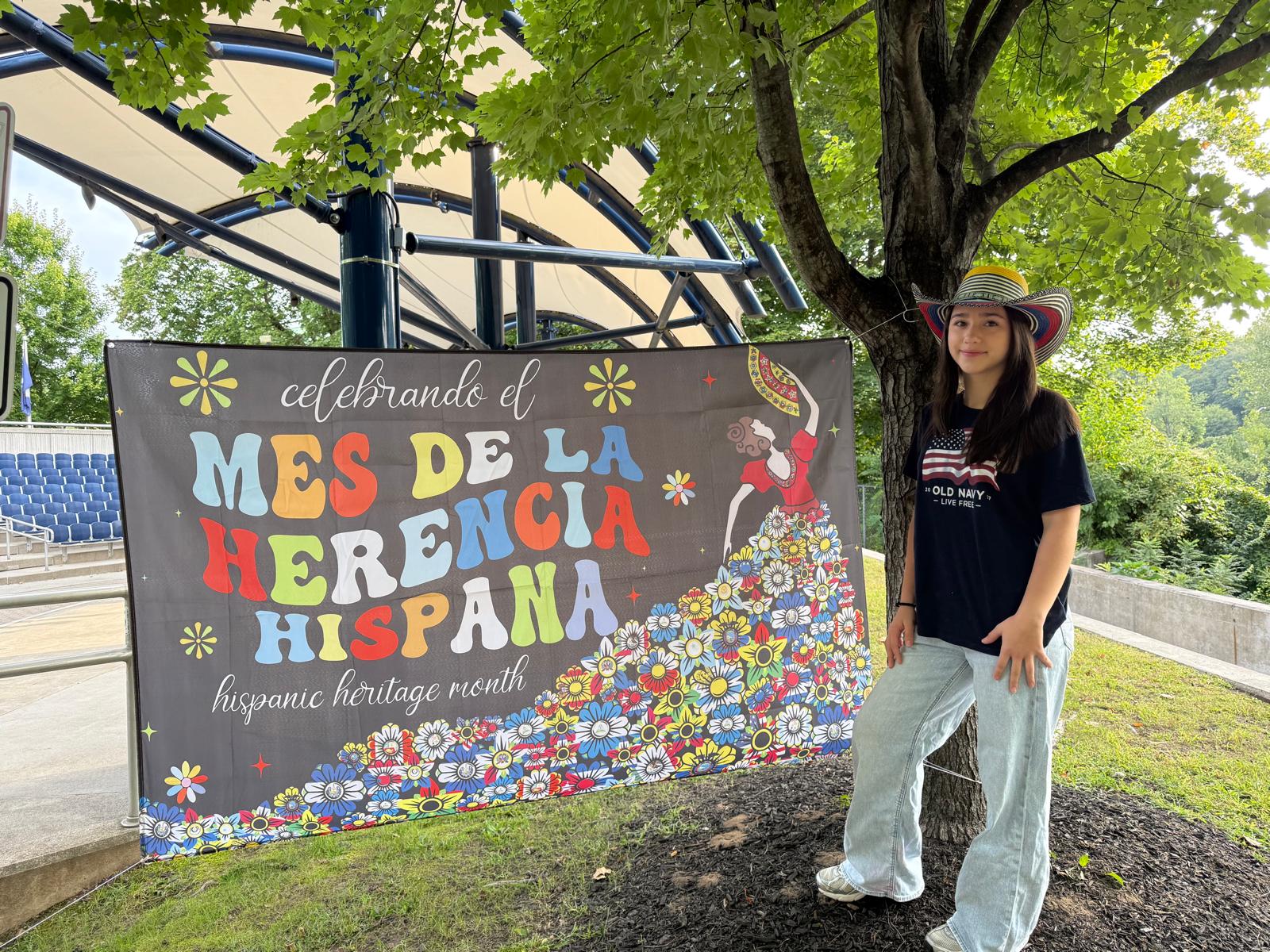 Festival representative beside a Hispanic Heritage Month banner